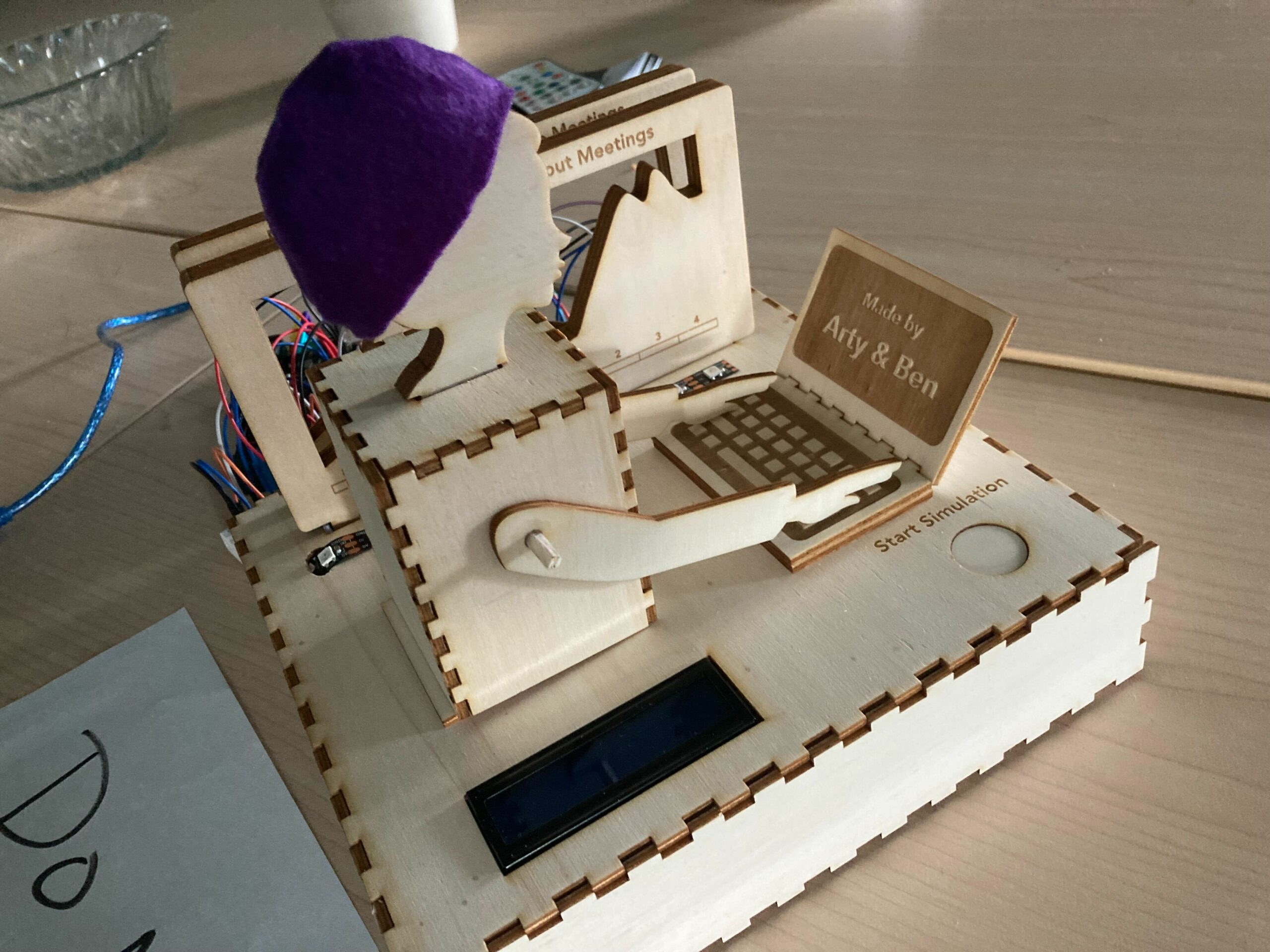 Lasercut person typing on lasercut laptop with Arduino to coordinate arm movement.